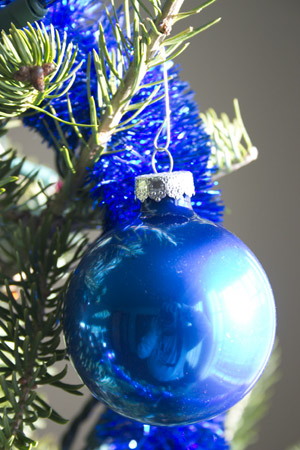 Close-up of a Christmas ornament hanging on our tree, reflecting me with camera